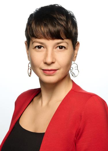 Portrait einer kurzhaarigen Frau mit rotem Blazer